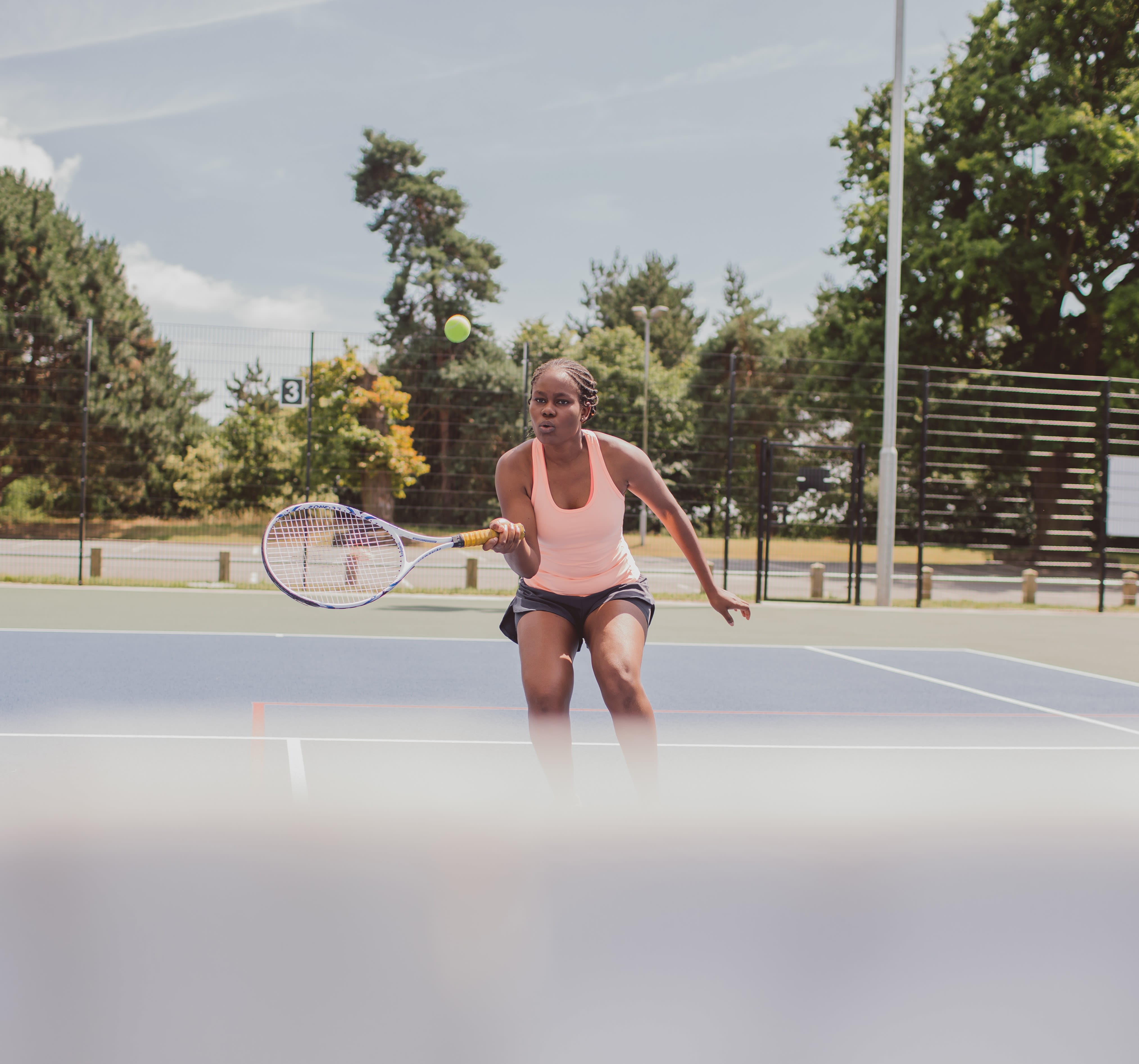 Student playing tennis in the sunshine