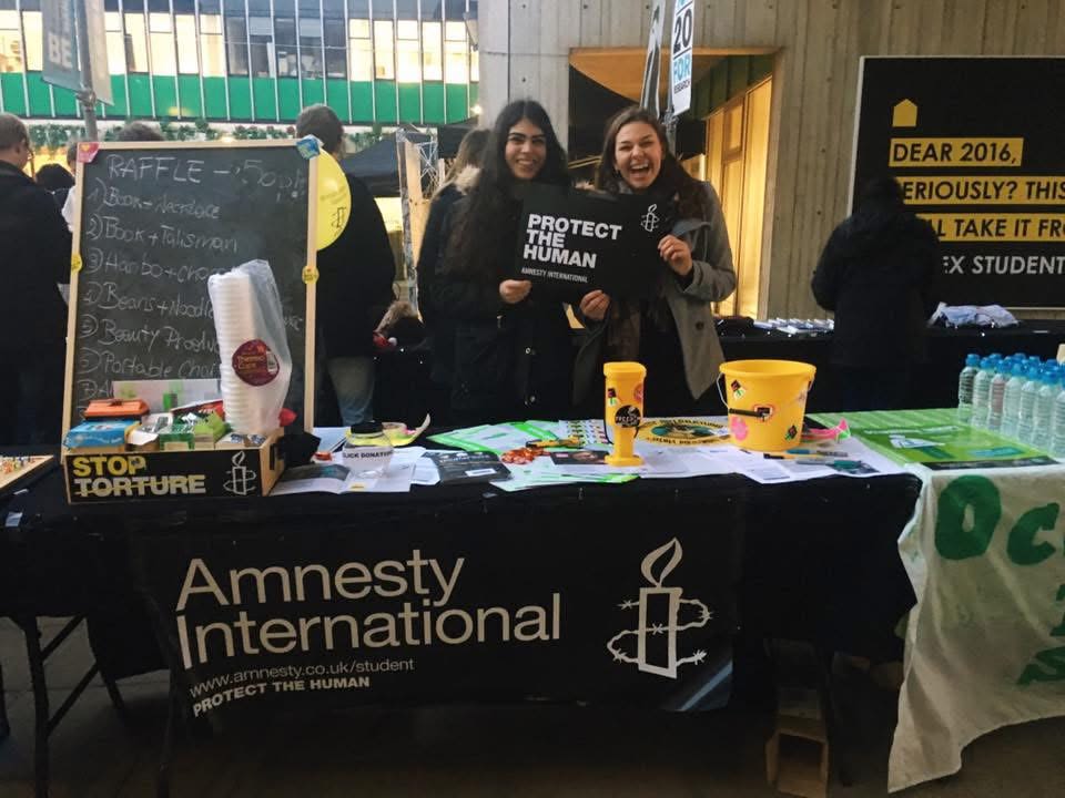 Ela and a friend stood in front of an Amnesty International table on an event on the squares