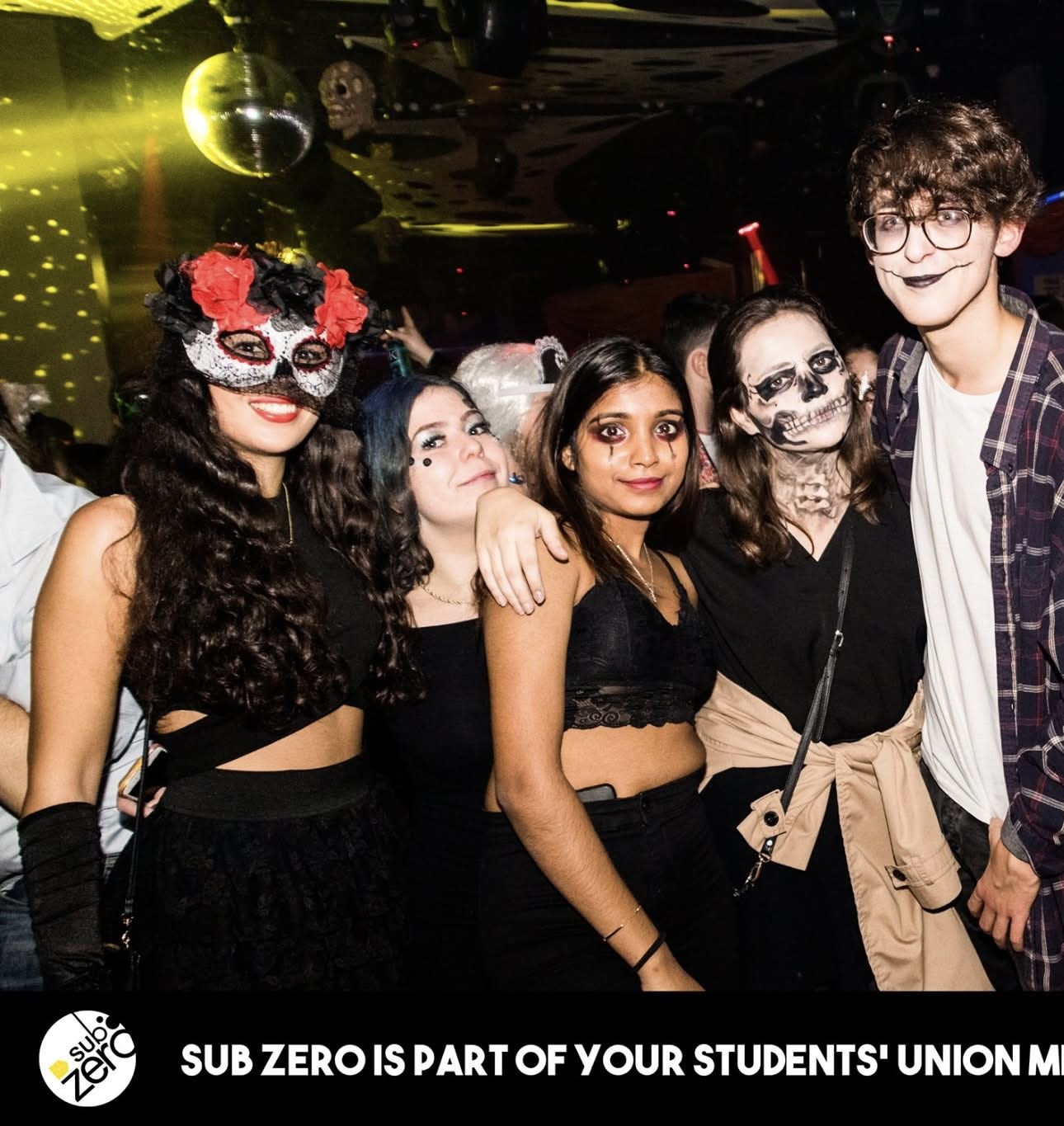 A group of students on a  night out. They all have face paint or masks on.