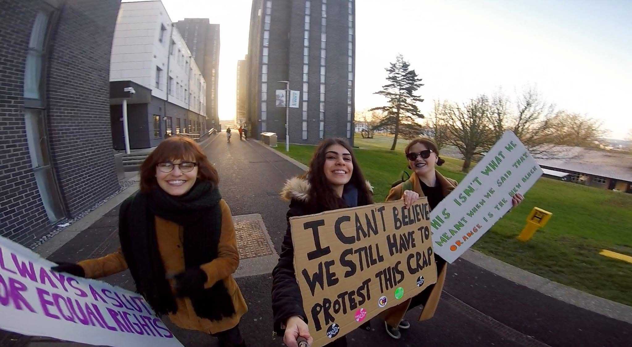 Ela and two friends holding cardboard signs
