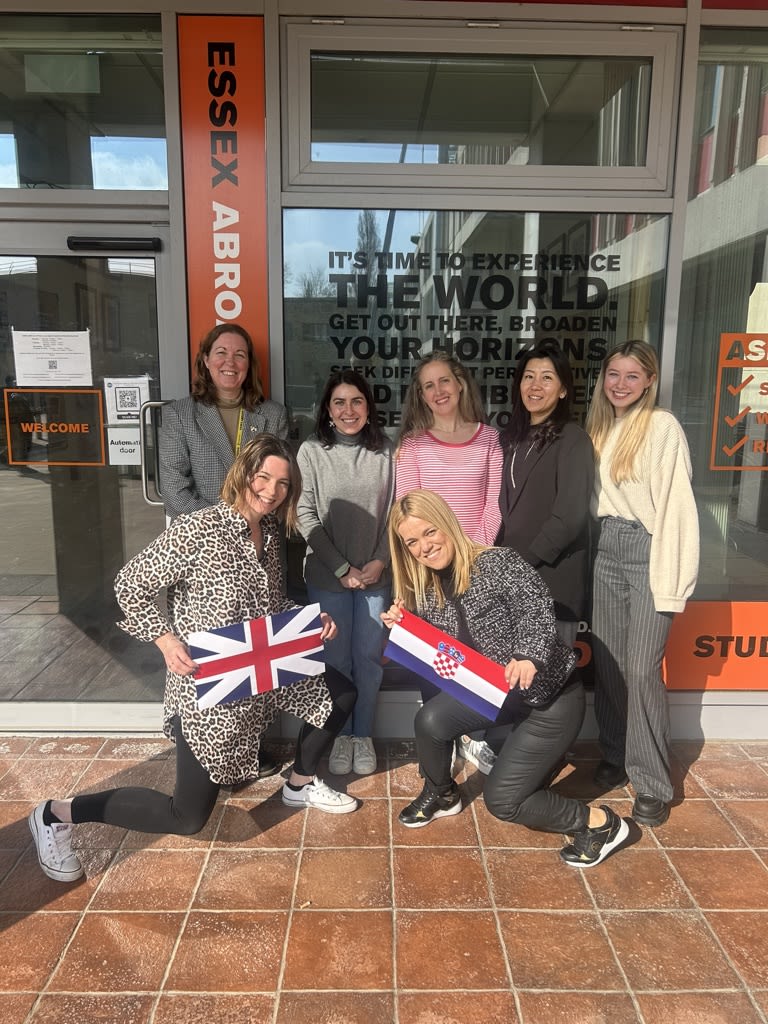 Group of staff for Essex Abroad holding flags