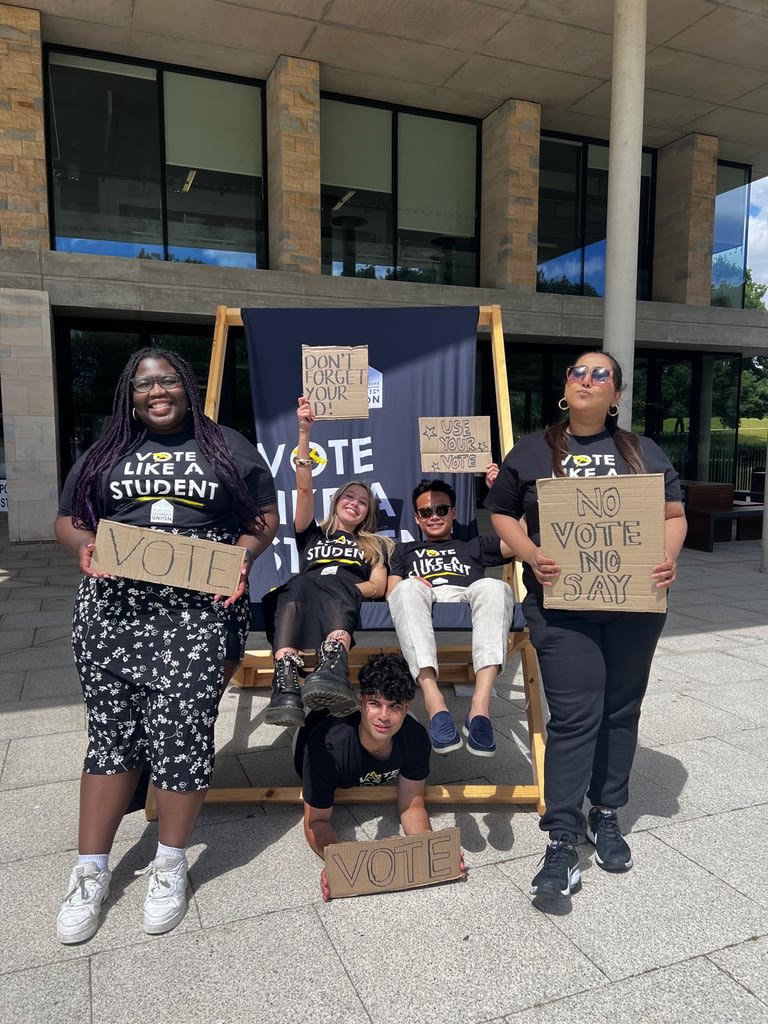Group of SU candidates holding banners encouraging students to vote