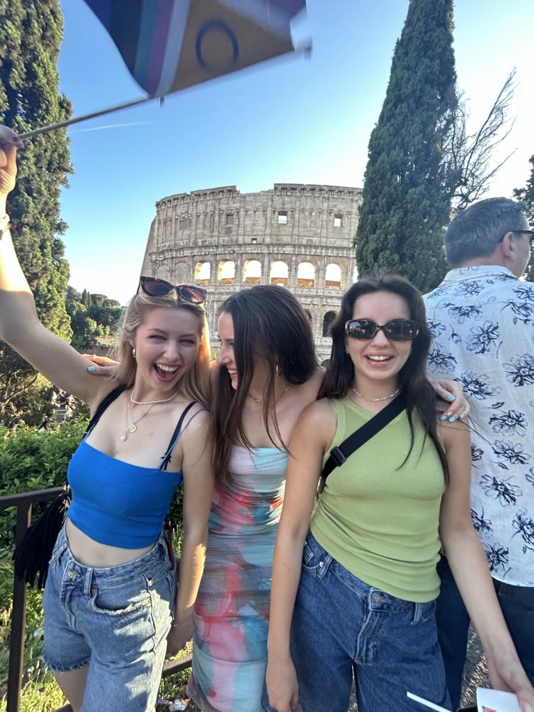 Lily-May with 2 friends laughing stood in front of the colosseum 