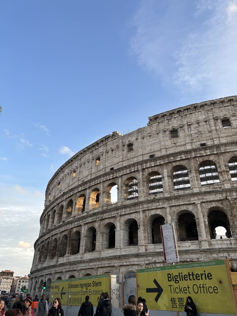 Colosseum in the foreground with blue skies behind it