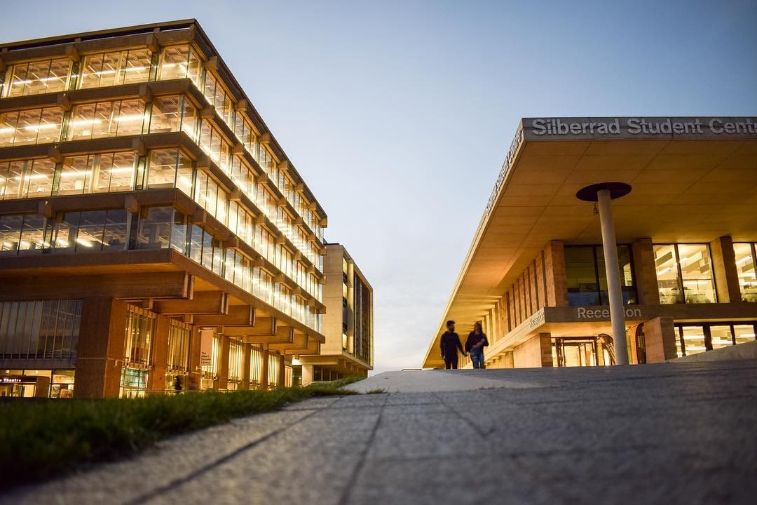Twilight on Colchester campus. The Library and Silberrad lights are on.