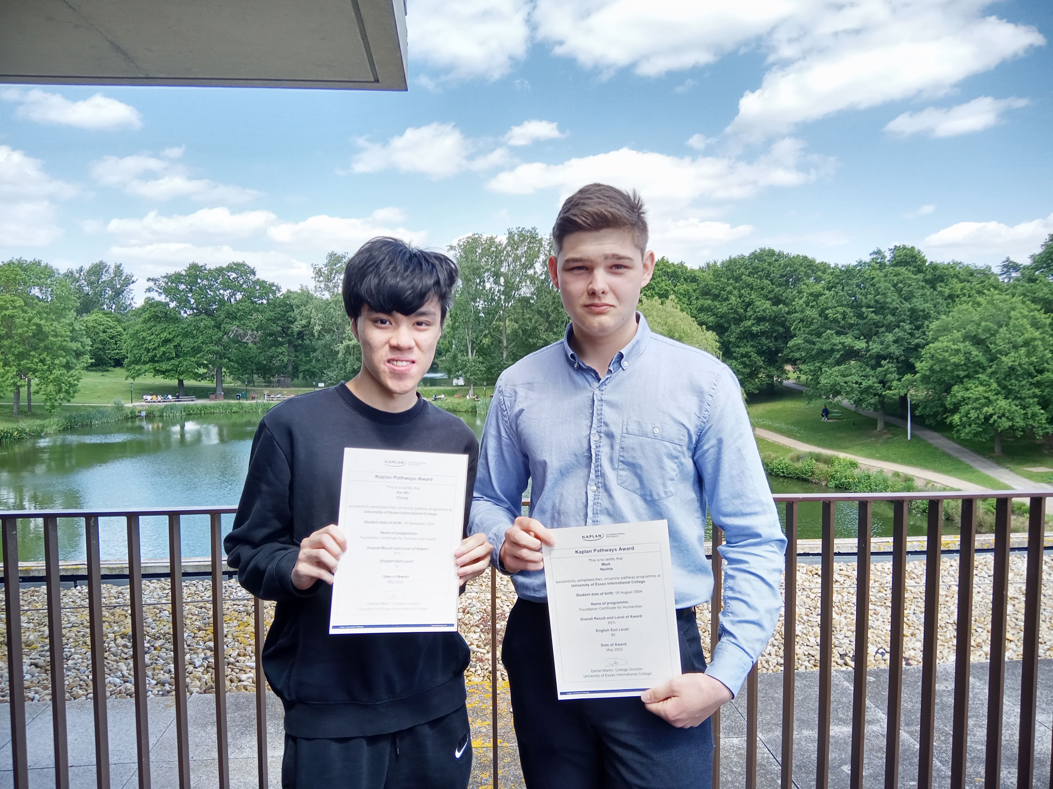 Mark and a friend are stood holding certificates of completion of they Kaplan entry courses