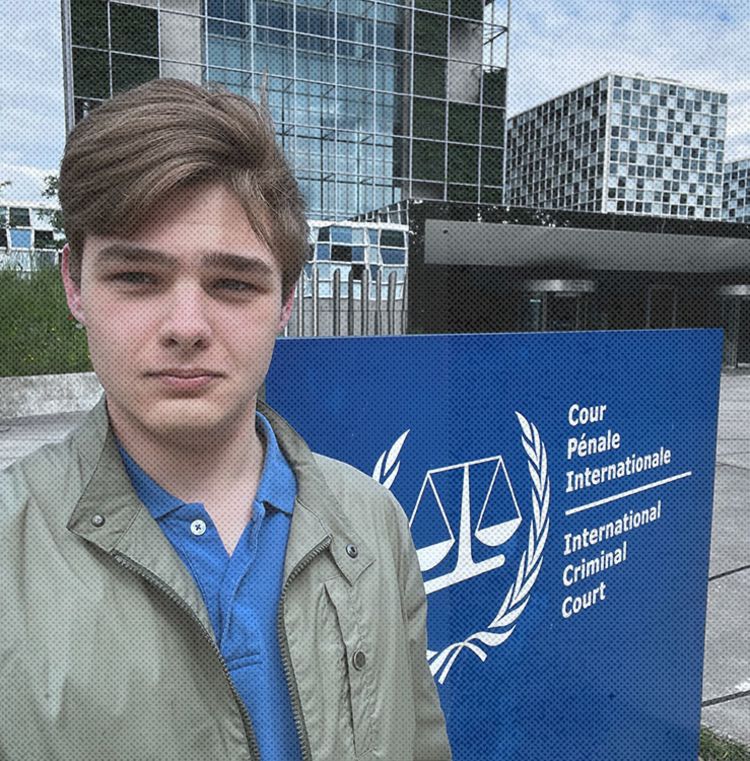 Mark stood in front of the International Criminal Court. The sign for the building is also in view.