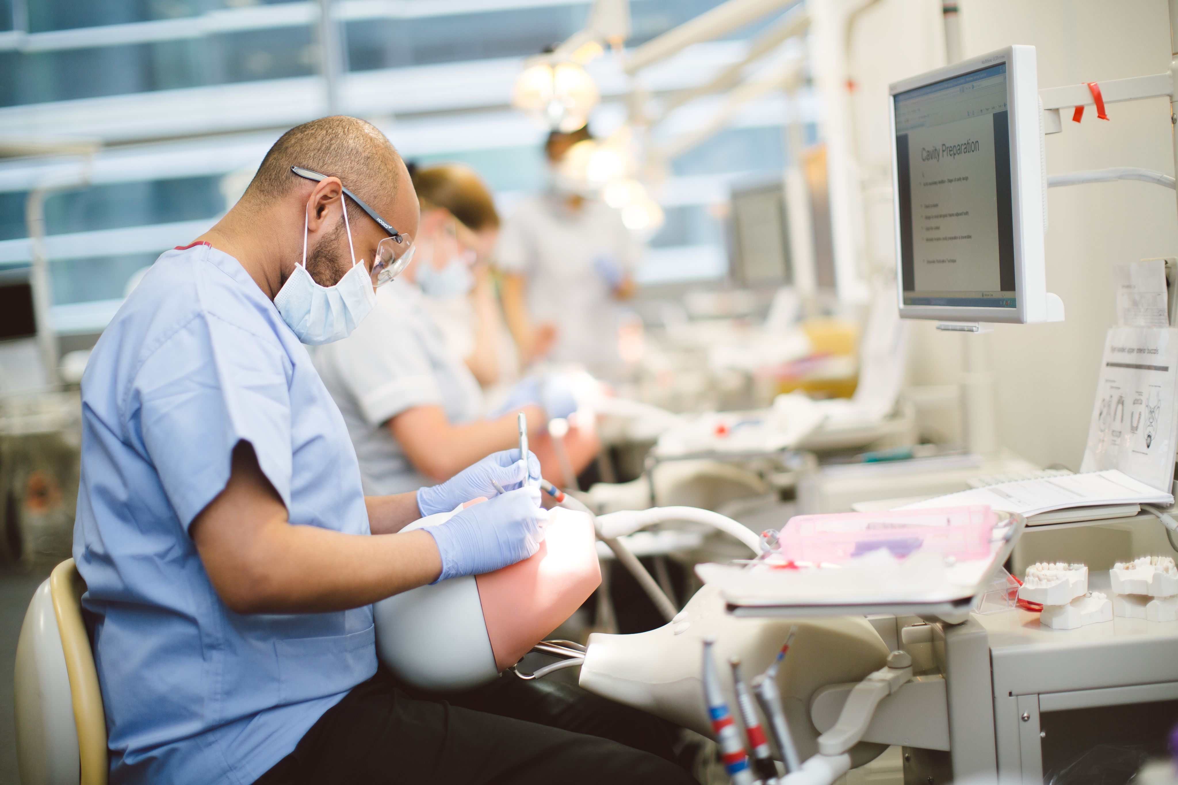 Student practicing dental work with model head