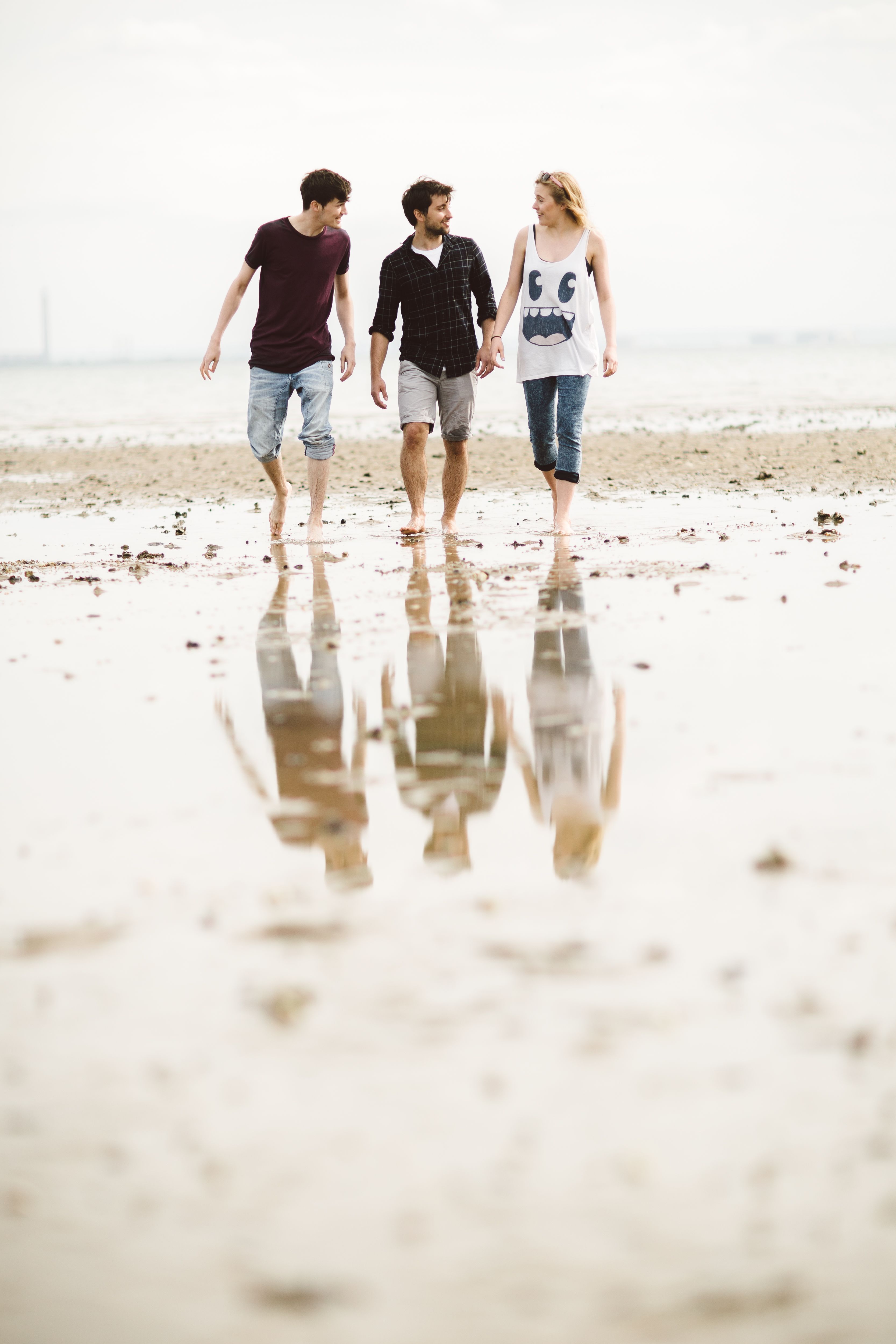 Students walking along the beach with the water reflecting