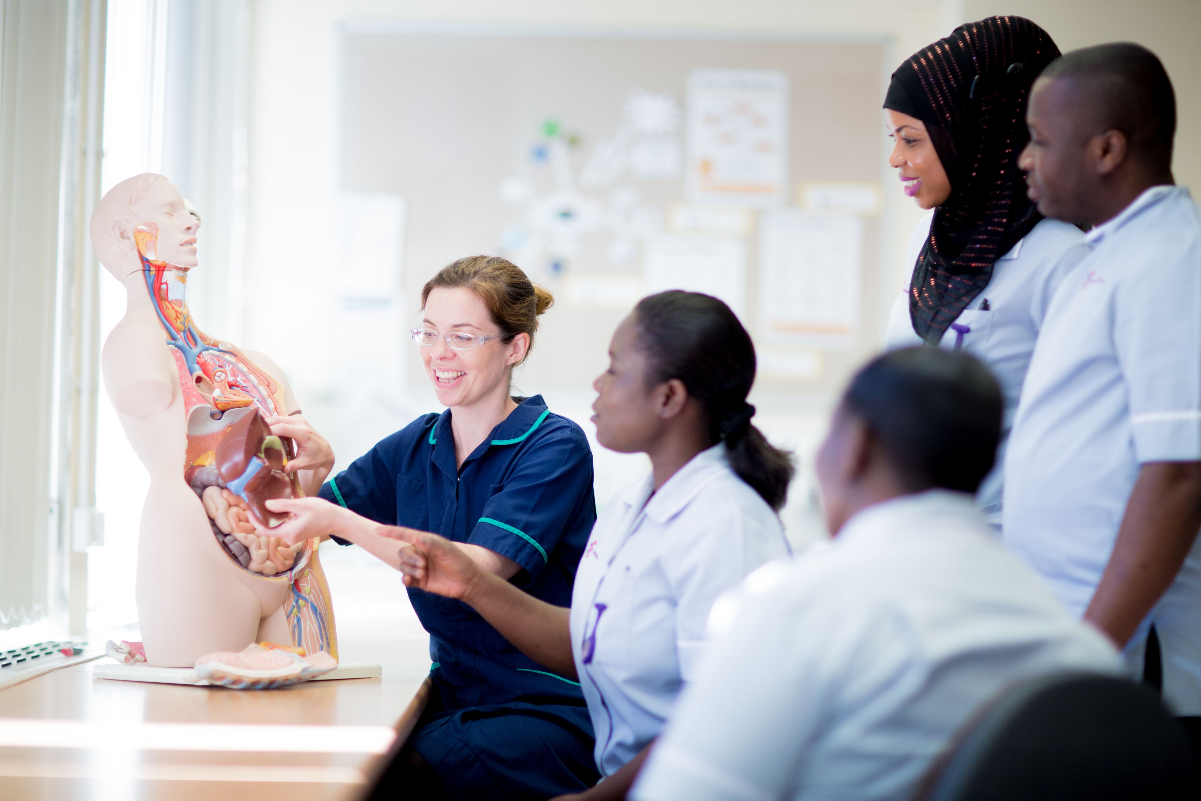 Professor teaching students with model of human body
